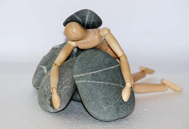 wooden figure, stones, struggle for life